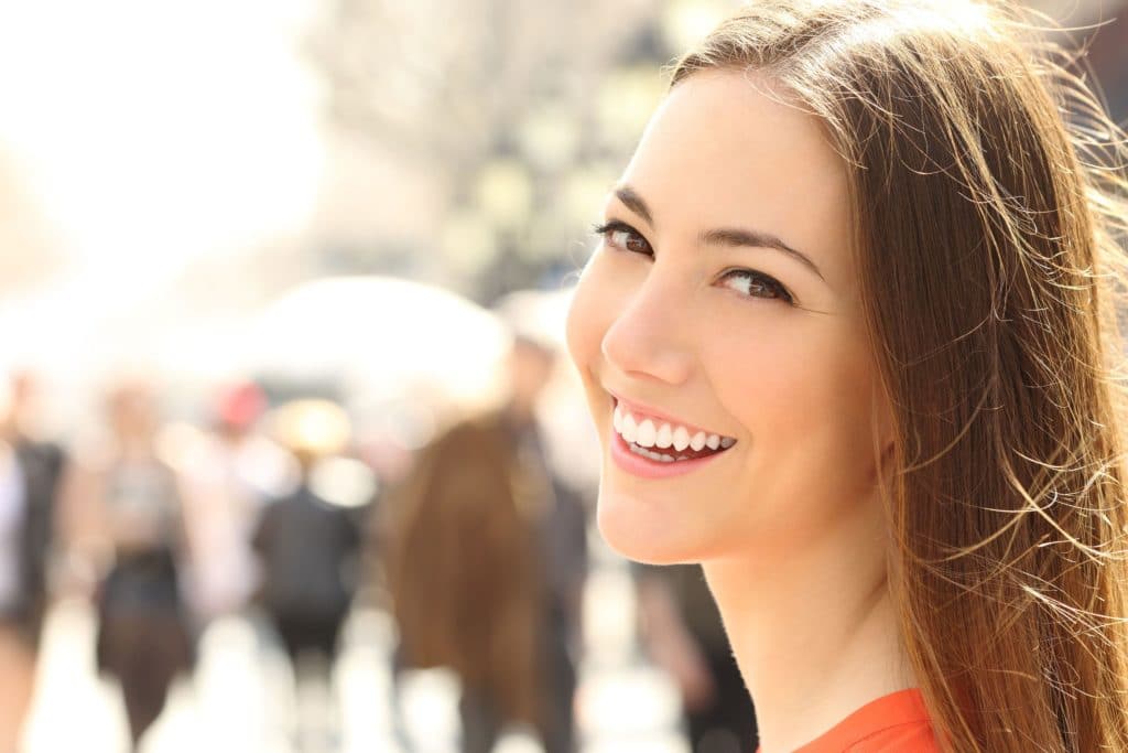 Young woman in crowd smiling with white fillings