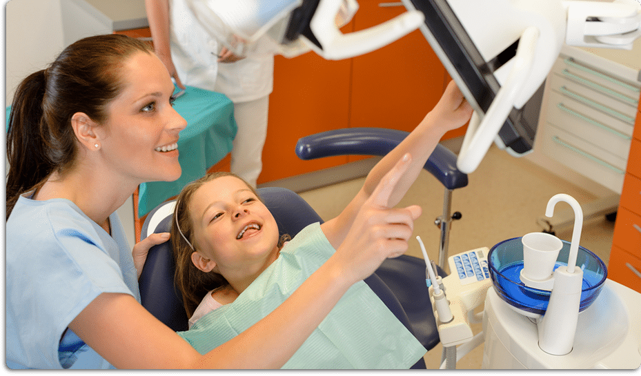 Family dental hygienist and young girl in dental chair pointing at x-ray