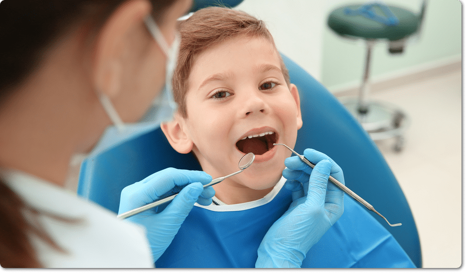 Family dentist checking happy young boy's teeth in Stoney Creek dental clinic