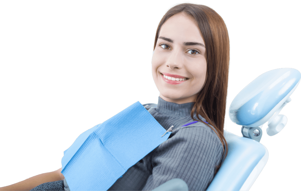 a woman smiling while sitting in a dental chair