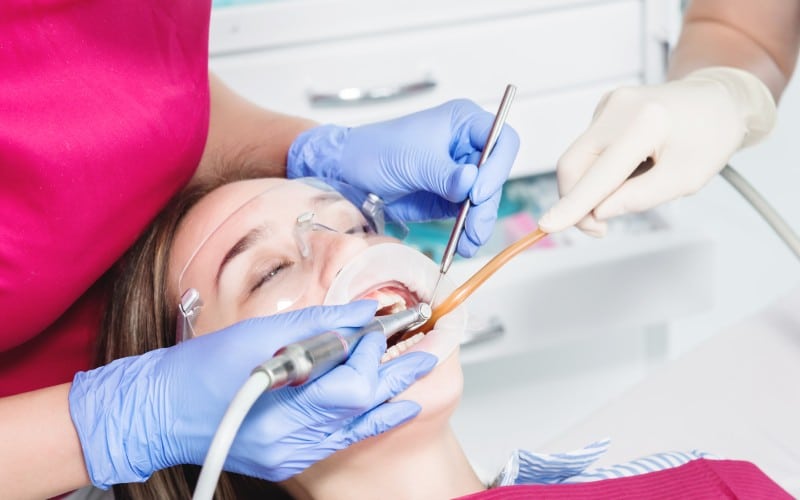 close up a young girl in-a dentists chair undergoes a routine diagnosis after removing