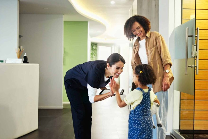 Friendly dentist greeting a young child and parent in a modern Stoney Creek dental clinic, creating a welcoming atmosphere for family dental visits