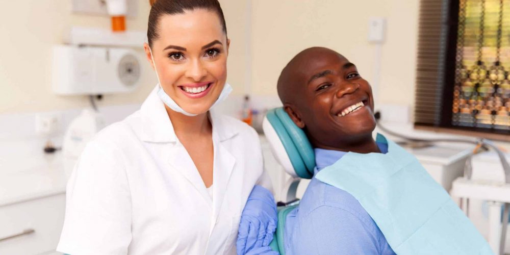 Dentist smiling with confident patient in dental chair in Stoney Creek dental office