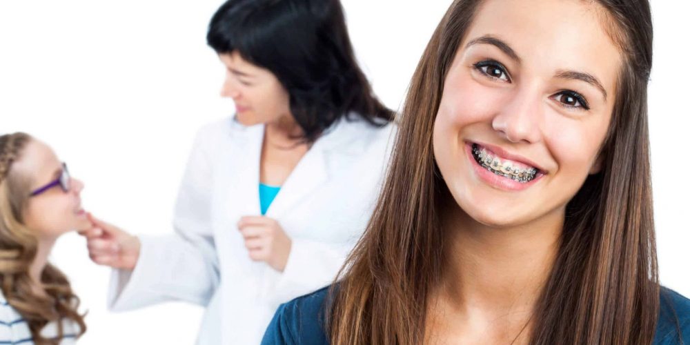 Smiling teenage girl with braces visiting pediatric dentist