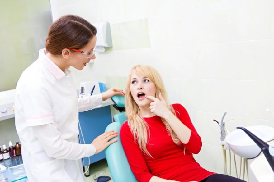 woman patient in dentist office getting consultation from doctor